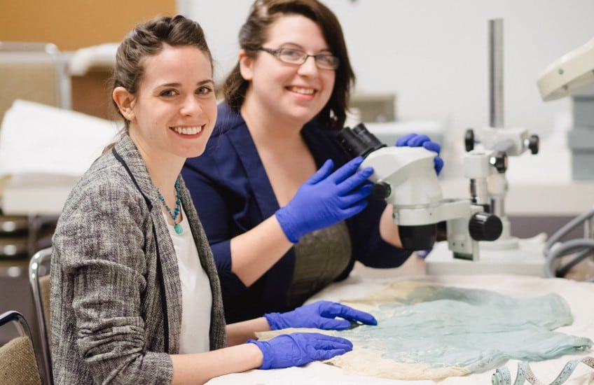 Sophia Zweifel (l) and Gennifer Majors (r) working on garments in the Agnes’s holdings. Photo: Tim Forbes