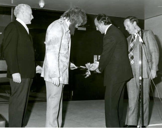 Ribbon cutting at opening of second building extension, with Chancellor Roland Michener and Michael Bell, Director, 1975