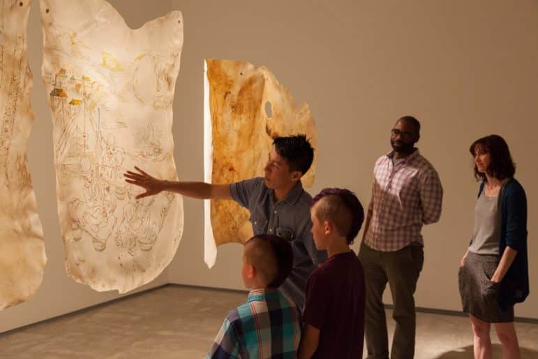 Howie Tsui, artist, with visitors in Howie Tsui Friendly Fire, 2012