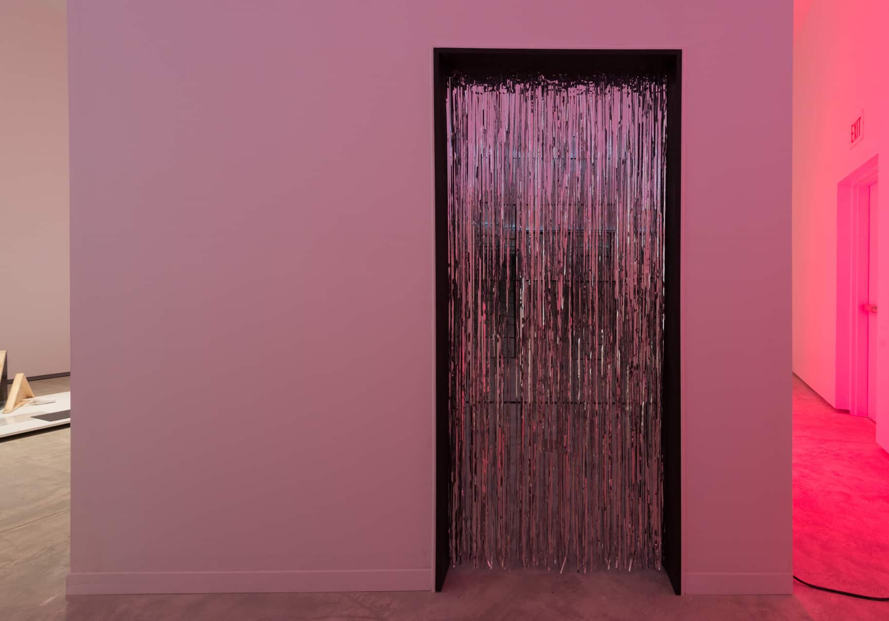 Installation image of the shiny tassled curtain doorway into Teresa Carlesimo and Michael DiRisio's artwork titled, "a form of formlessness."