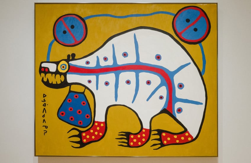 A painting of a white bear with three legs seen. It has red feet and is carrying a medicine bag around its neck. The bear is placed on a mustard yellow background.