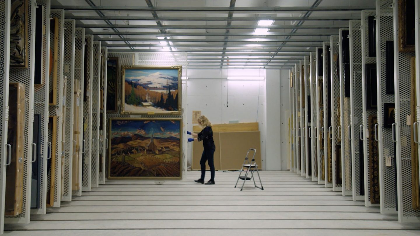 Marla Dobson pulls out a rack of paintings in the Agnes vaults.