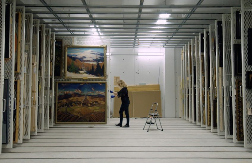 Marla Dobson pulls out a rack of paintings in the Agnes vaults.