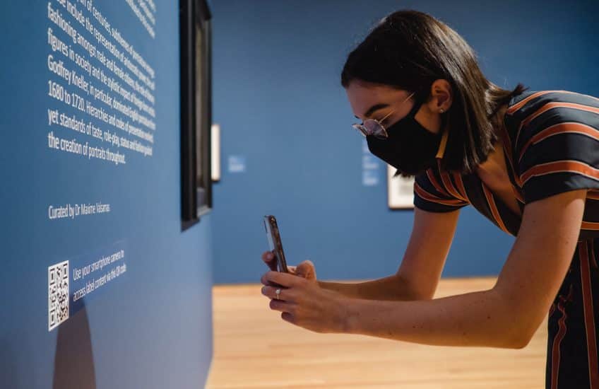 A visitor uses the QR codes in the gallery