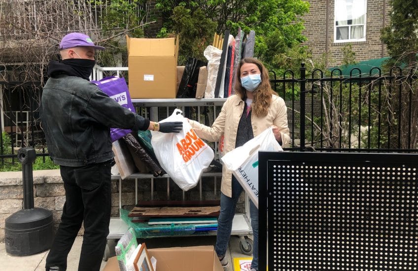 Tatum Dooley and a volunteer arranging work on a cart to be delivered to Fudger House.