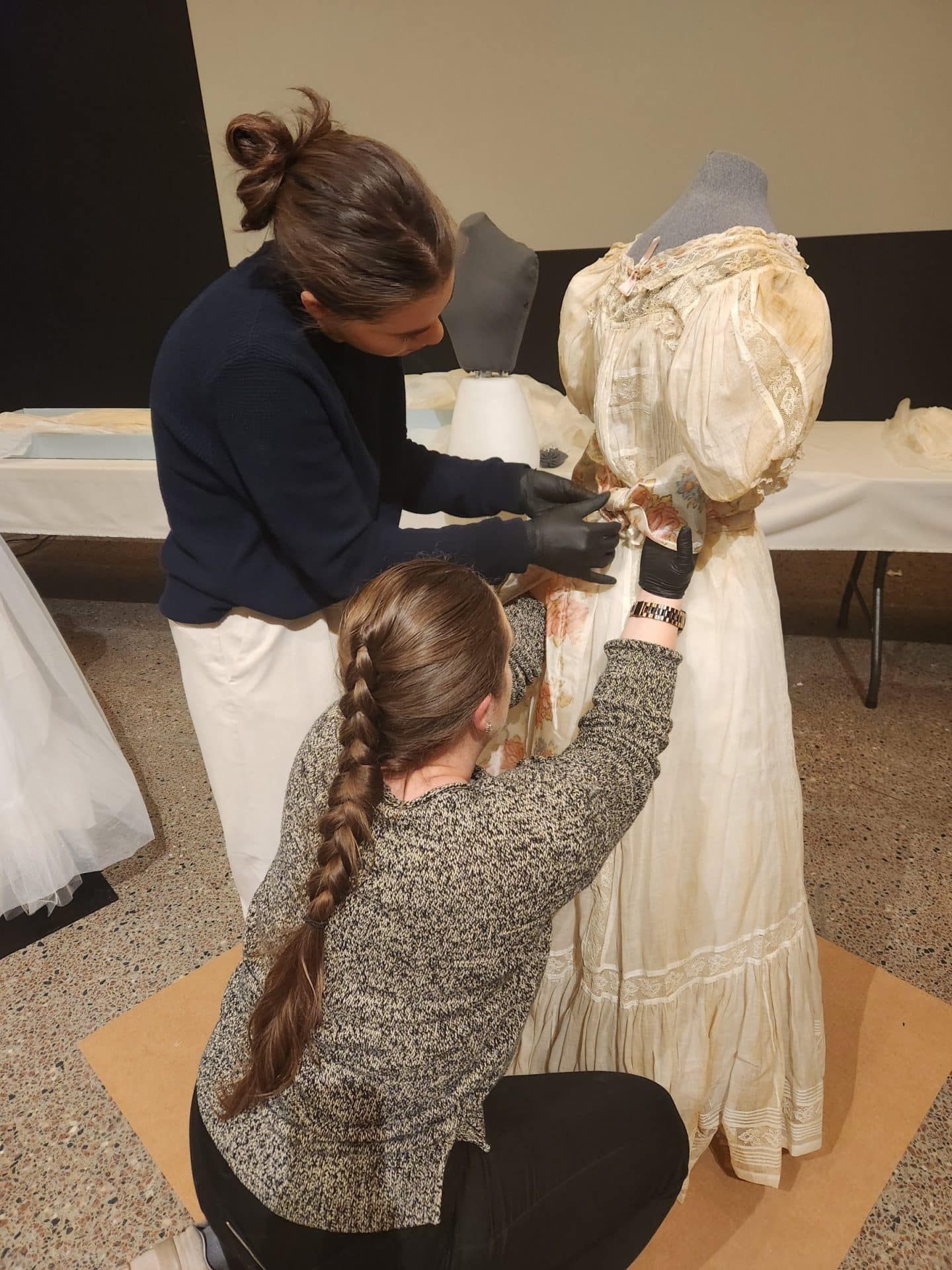 Marissa Monette, Textile Conservation Technician and Julia Popsin-Gomes, Textile Technician Assistant work together to mount a dress.