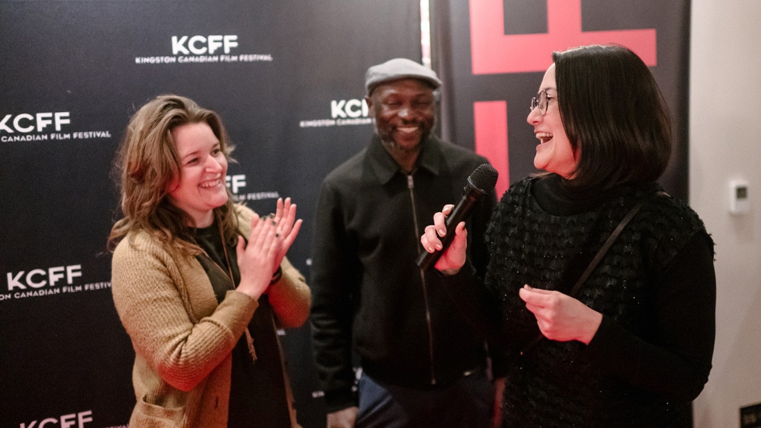 Naomi Okabe accepts the award for Best Local Short Film at the Kingston Canadian Film Festival, alongside Chaka Chikodzi and Tess Girard.