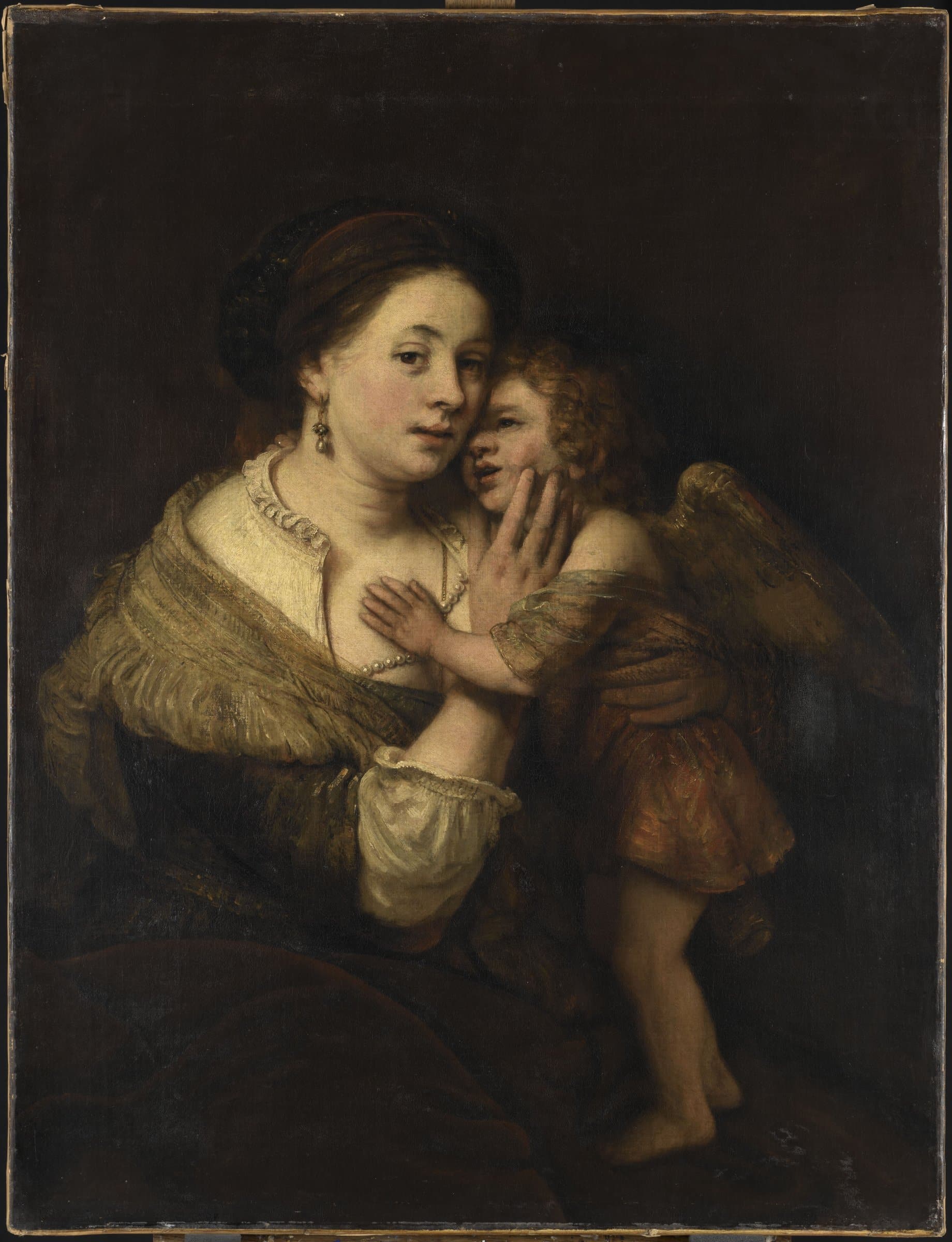 A woman wearing silk gown is seated while holding a winged child whose head rests against her cheek and hand on her chest.