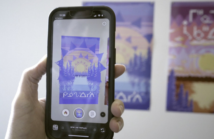 A phone looks at augmented reality artworks by Dallas Flett-Wapash.