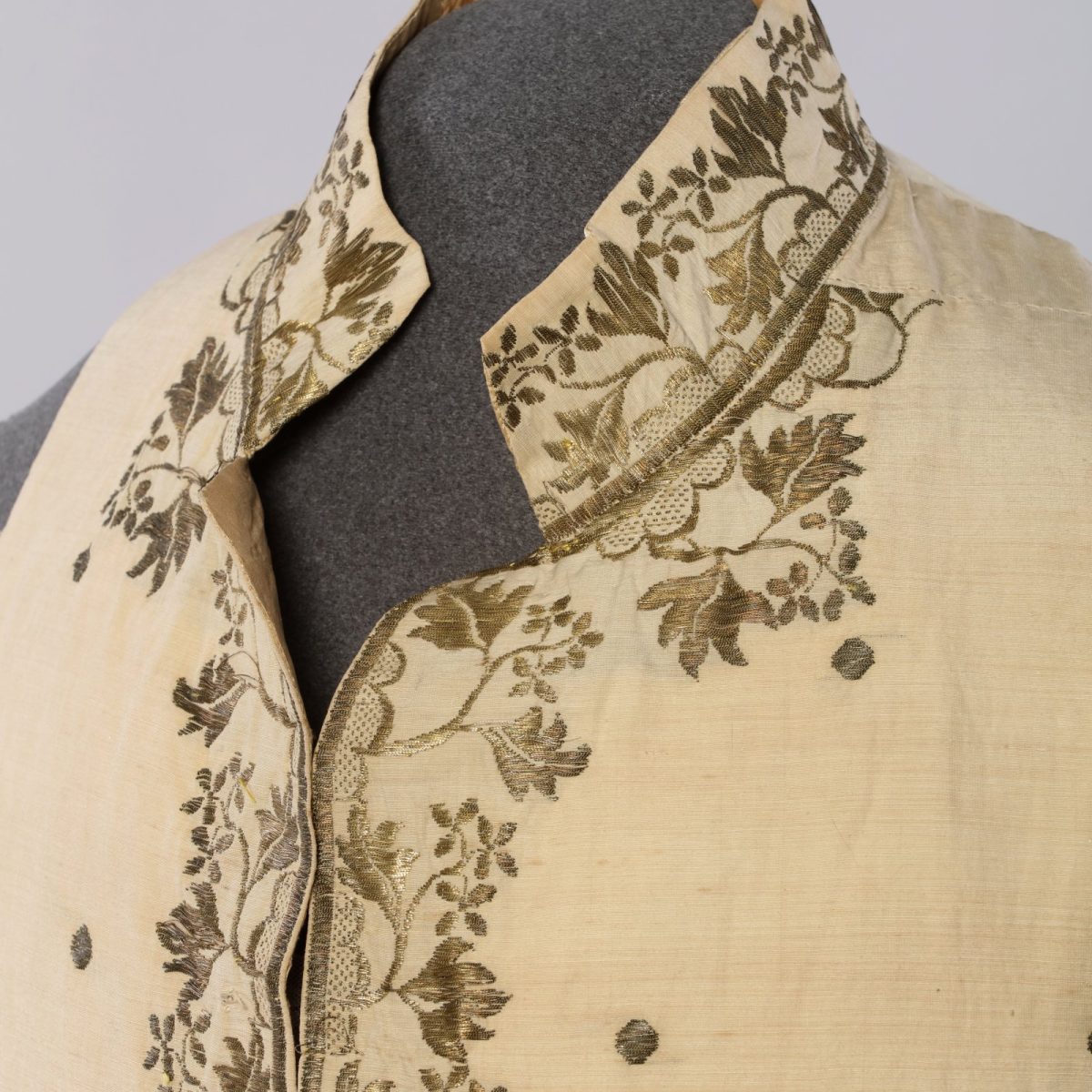 Close-up of the neckline embroidery of the cream-coloured waistcoat.