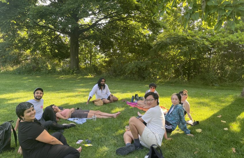 Group of people sitting on the grass in a park on a sunny day