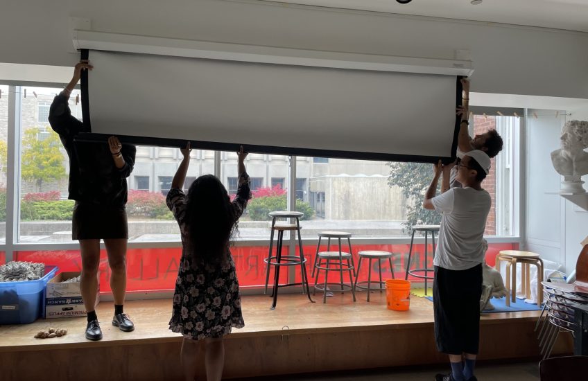 Living Intuition Residency: Artists work together to install a projection screen.