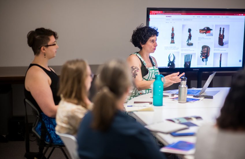 Members of faculty and team Agnes are seated around a table with Agnes objects on a screen during a workshop