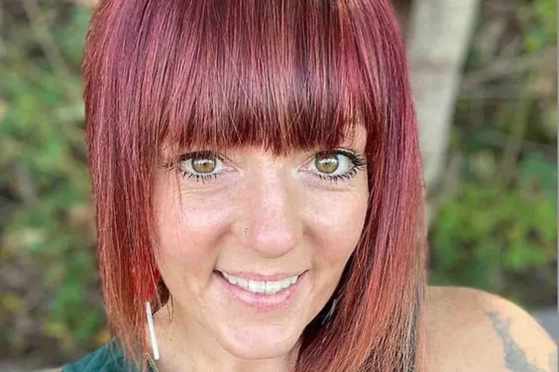 Red-headed white woman smiling into the camera