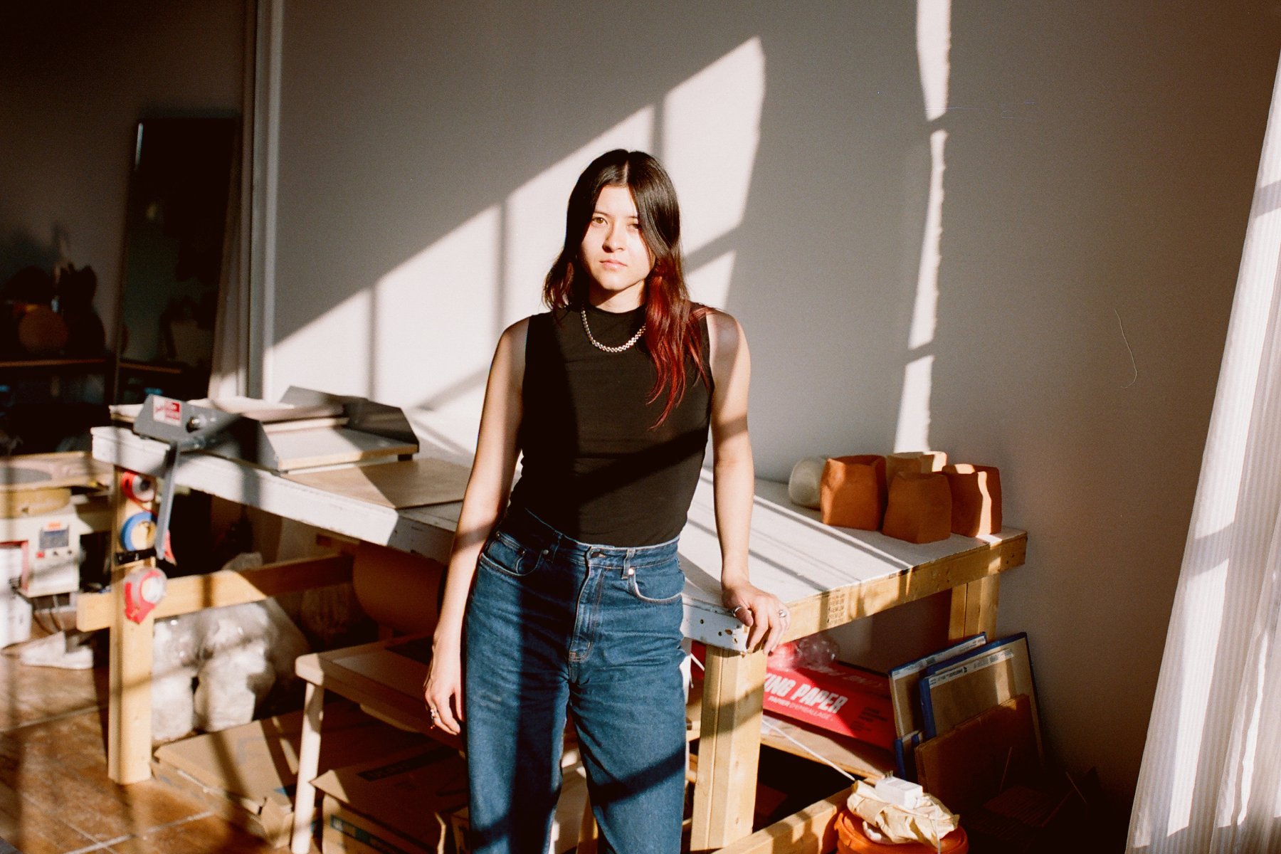 Woman standing in a studio with sunlight streaming in