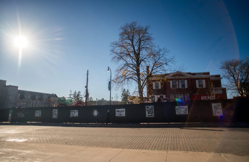 billboards in front of a construction site. The billboards have prints on them.