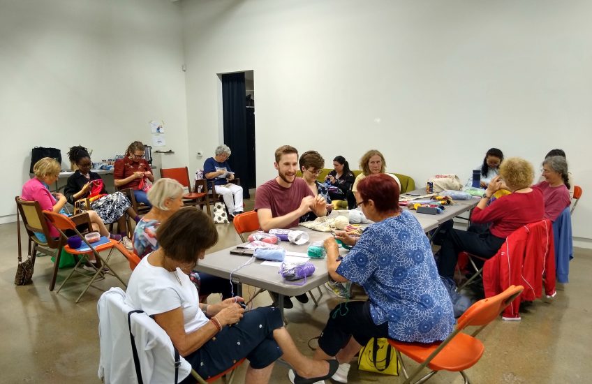 Tables of people crocheting