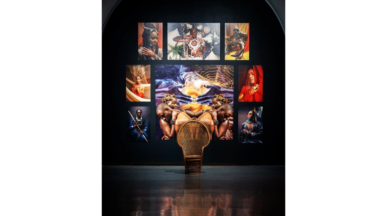 A frontal view of a gallery wall with digital photography and a rattan peacock chair in an art gallery.
