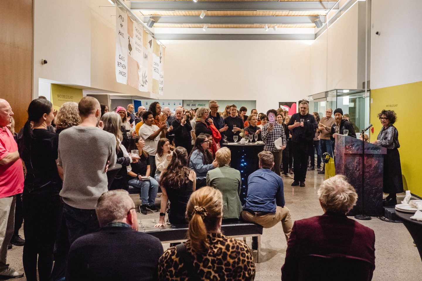 Large audience of people listening to a person speak at a podium