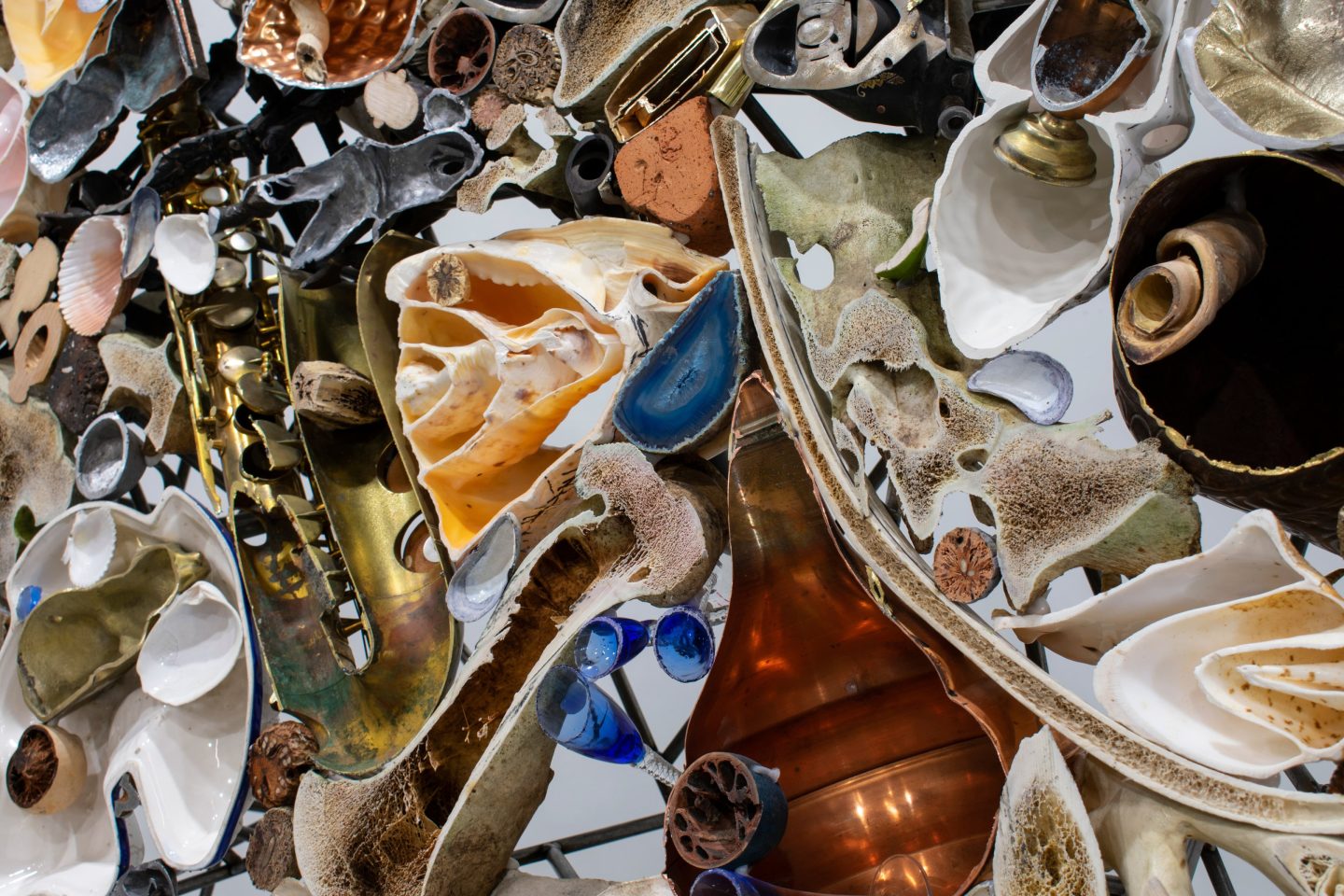 close up of a multi-media free standing sculpture. It is made out of teacups, plates and other pieces of china